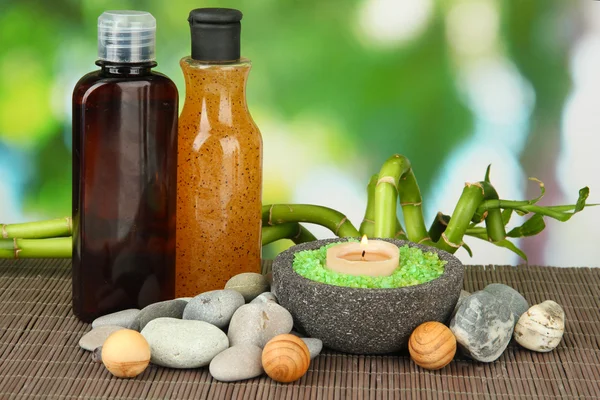 Bodegón con planta de bambú verde y piedras, sobre estera de bambú, sobre fondo brillante — Foto de Stock