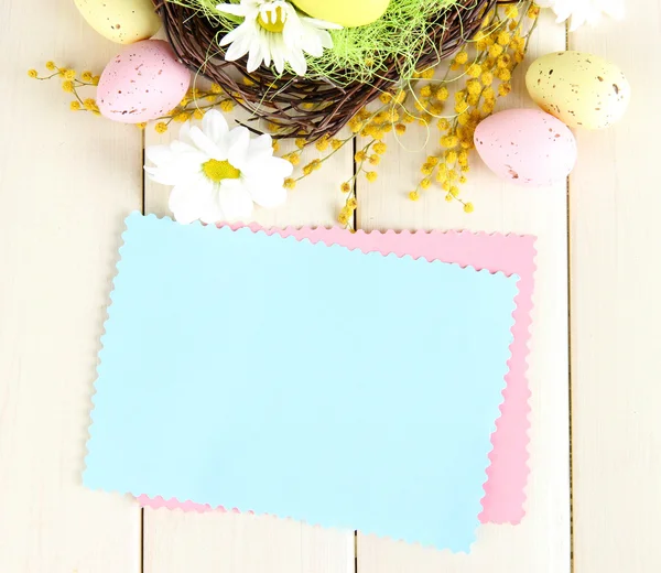 Empty card with easter eggs and mimosa flowers, on white wooden background — Stock Photo, Image