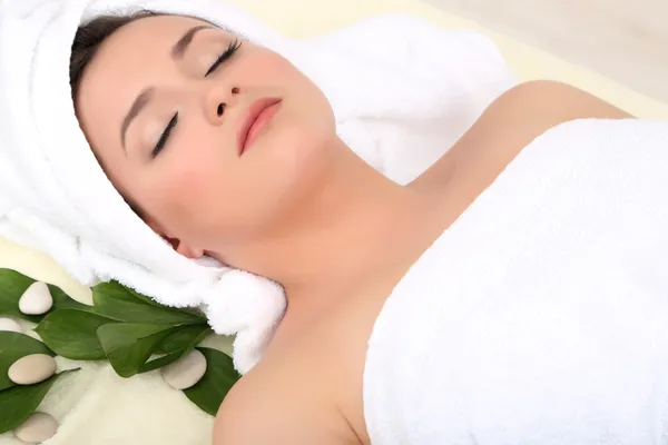 Beautiful young lying in spa salon — Stock Photo, Image