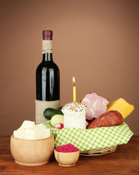 Påsk korg: begreppsmässig foto av traditionell påsk mat i flätad korg, på träbord på färgbakgrund — Stockfoto