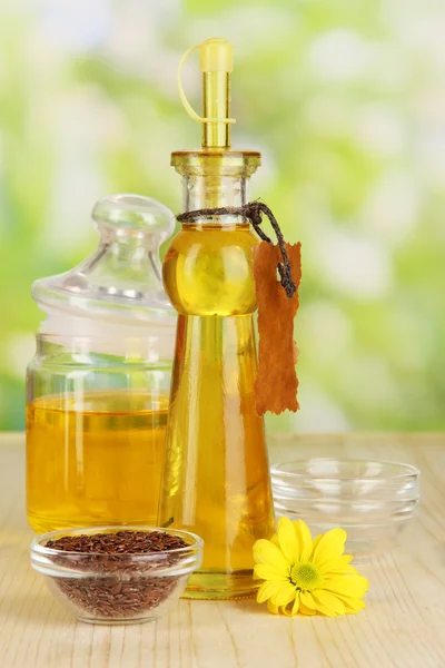 Useful linseed oil on wooden table on natural background — Stockfoto