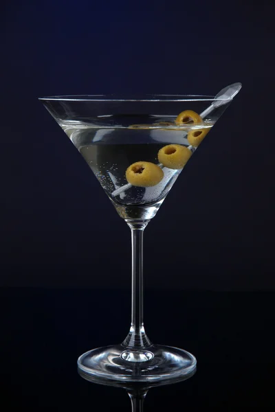 Martini glass with olives on dark blue background — Stock Photo, Image