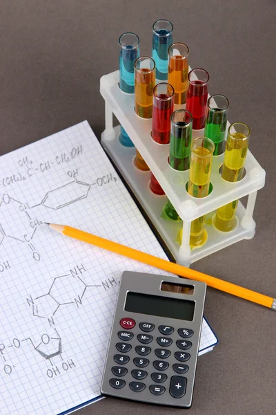 다채로운 액체와 회색 배경에 수식을 테스트 튜브 — 스톡 사진