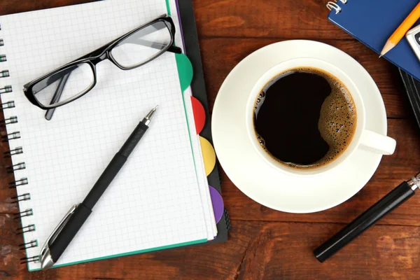 Xícara de café na mesa de trabalho coberto com documentos de perto — Fotografia de Stock