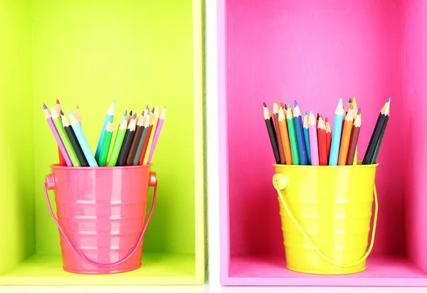 Colorful pencils in pails on shelves — Stock Photo, Image