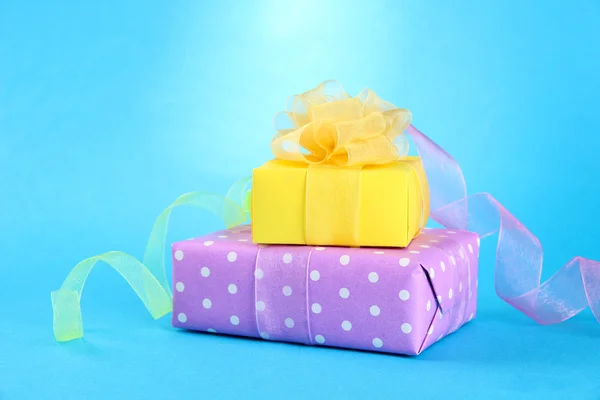 Bright gifts with bows on blue background — Stock Photo, Image