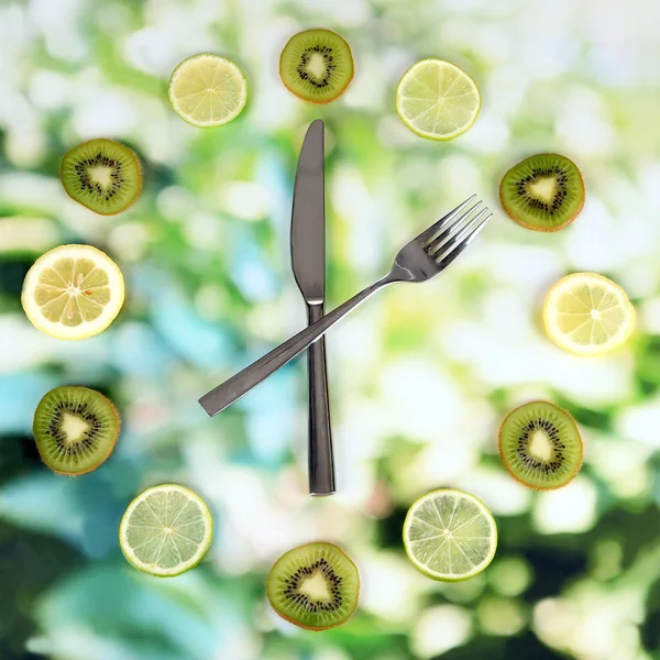 Часы из киви, лайма и лимона, на ярком фоне — стоковое фото