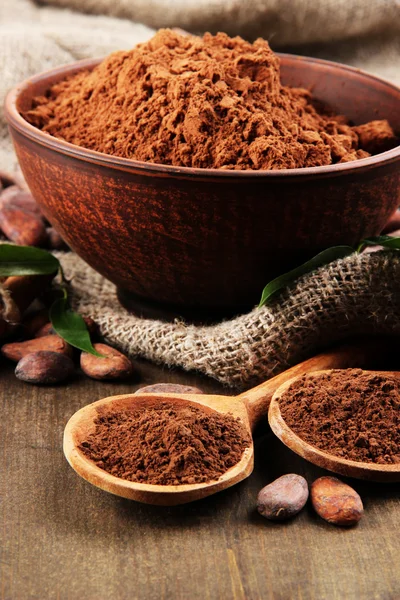 Cacao en polvo y granos de cacao sobre fondo de madera —  Fotos de Stock