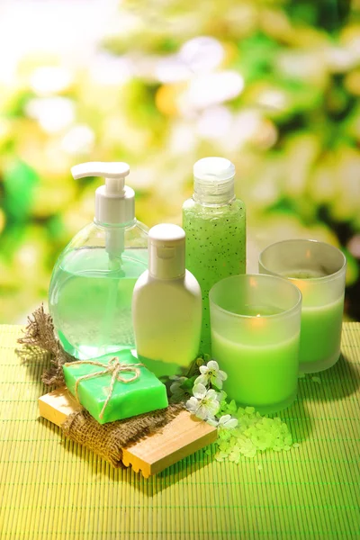 Botellas de cosméticos y jabón natural hecho a mano sobre fondo verde —  Fotos de Stock