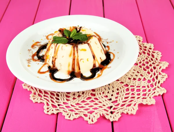 Panna Cotta with chocolate and caramel sauce, on color wooden background — Stock Photo, Image