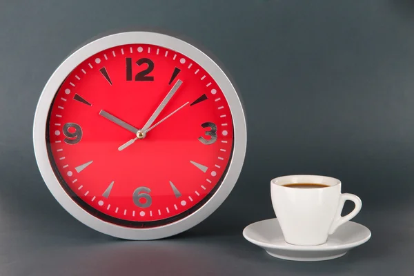 Cup coffee and clock on gray background — Stock Photo, Image