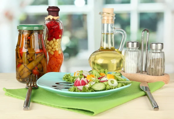 Salade fraîche mélangée avec des œufs, des feuilles de salade et d'autres légumes sur plaque de couleur, sur fond lumineux — Photo