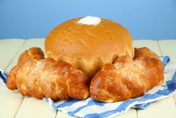 Komposition mit Brot, Brötchen und Serviette auf Holztisch, auf farbigem Hintergrund — Stockfoto