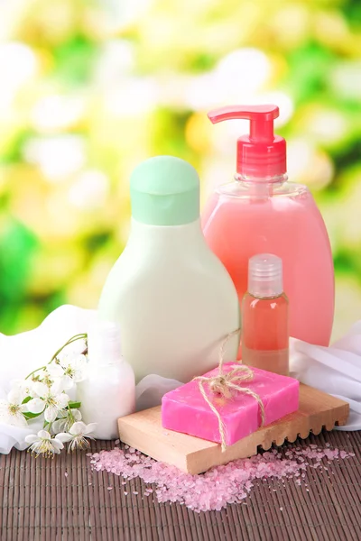 Cosmetics bottles and natural handmade soap on green background — Stock Photo, Image