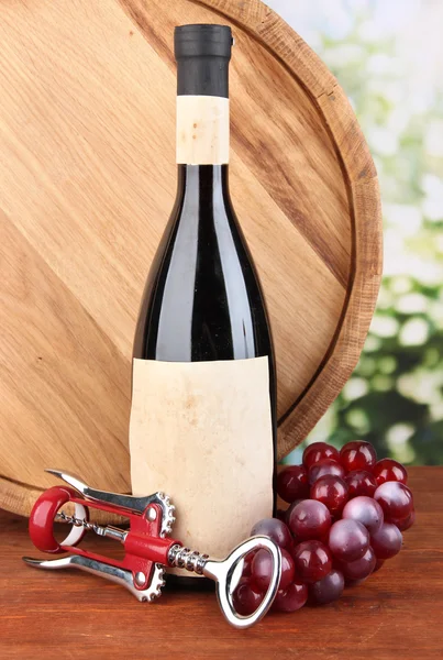 Composición de sacacorchos y botella de vino, uva, barril de madera sobre mesa de madera sobre fondo brillante —  Fotos de Stock