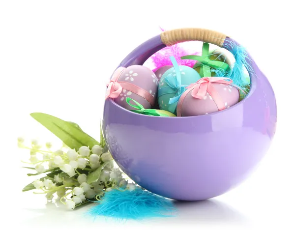 Beautiful easter eggs in basket and lilies of the valley, isolated on white — Stock Photo, Image