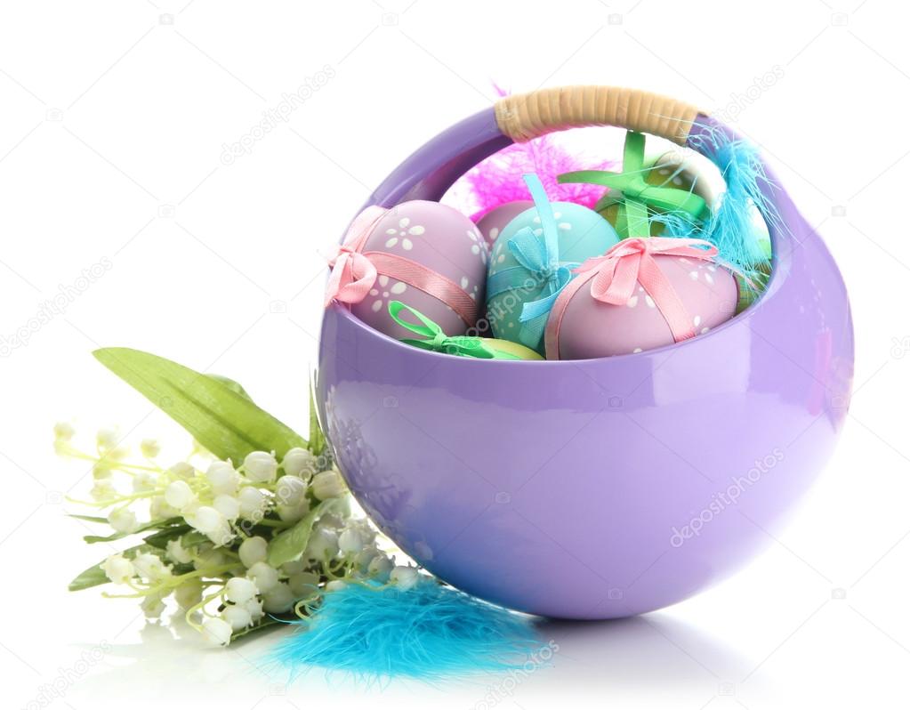 Beautiful easter eggs in basket and lilies of the valley, isolated on white