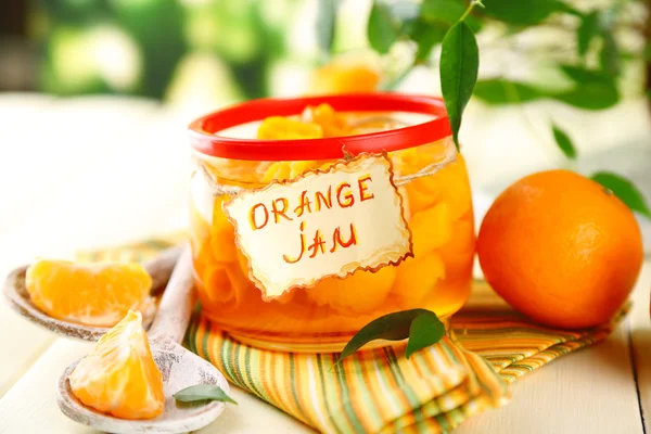 Engarrafamento de laranja com raspas e tangerinas, sobre mesa de madeira branca — Fotografia de Stock