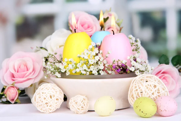 Pasen kaarsen met bloemen op achtergrond van venster — Stockfoto