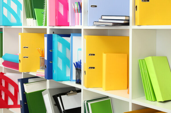 White office shelves with different stationery, close up