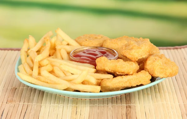 Fried chicken nuggets with french fries and sauce on table in park — Stock Photo, Image