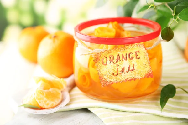 Engarrafamento de laranja com raspas e tangerinas, sobre mesa de madeira branca — Fotografia de Stock