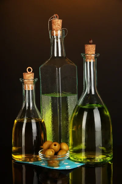 Original glass bottles with oil on dark color background — Stock Photo, Image