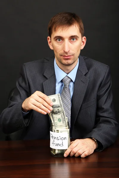 Ung affärsman med pengar på svart bak — Stockfoto