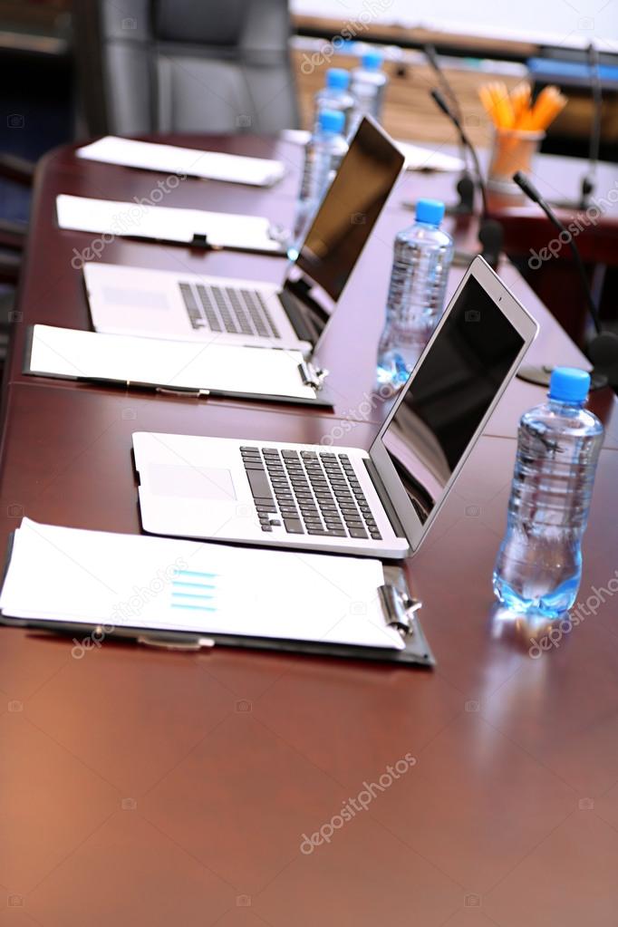 Empty conference room with laptops on table