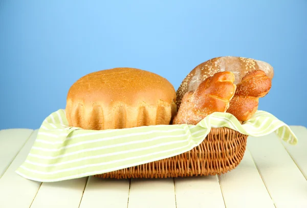 Composition with bread and rolls on wooden table, on color background — Stock Photo, Image