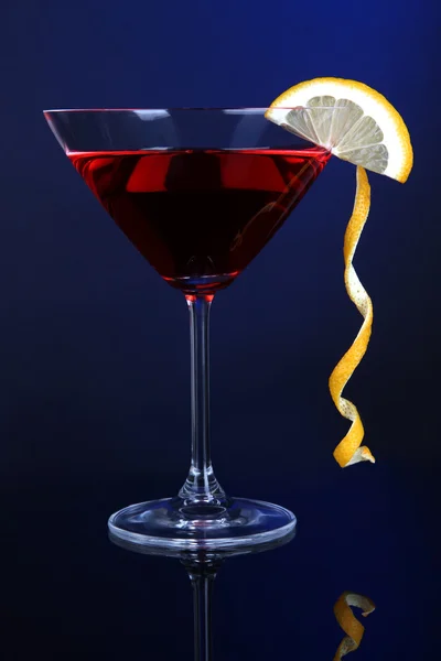 Cóctel rojo en vaso de martini sobre fondo azul oscuro —  Fotos de Stock