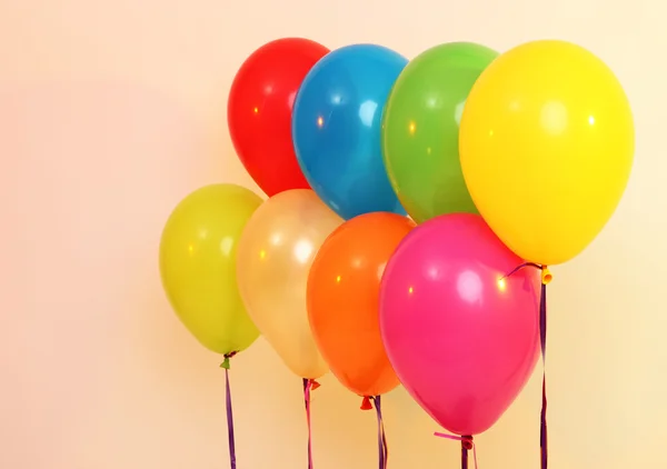 Veel heldere ballonnen op oranje achtergrond — Stockfoto