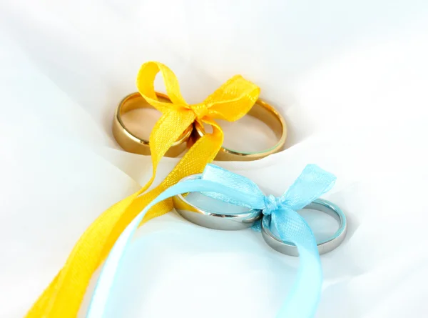 Wedding rings tied with ribbon on cloth background — Stock Photo, Image