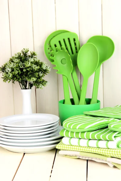 Kitchen settings: utensil, potholders, towels and else on wooden table — Stock Photo, Image