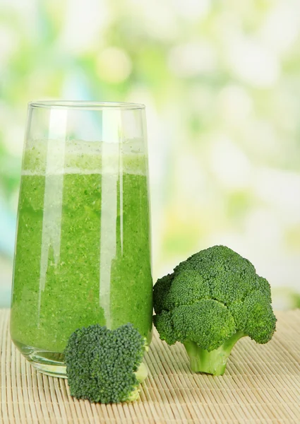 Glas Brokkolisaft, auf Bambusmatte, auf grünem Hintergrund — Stockfoto