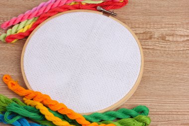 Masaya nakış işlemek için bez ve parlak dikiş iplikleri ile nakış çemberi