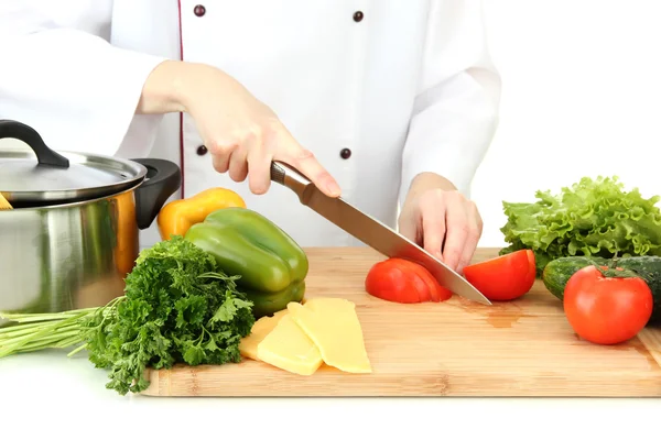 Mains féminines coupant des légumes, isolées sur blanc — Photo