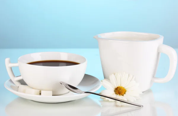 Uma xícara de café forte e creme doce no fundo azul — Fotografia de Stock