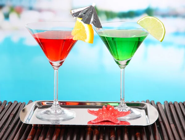 Bicchieri di cocktail sul tavolo vicino alla piscina — Foto Stock