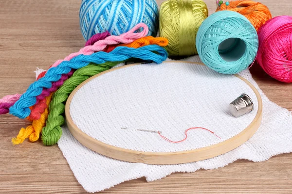 El aro de bordado con tela e hilos de coser brillantes para bordar en la mesa — Foto de Stock