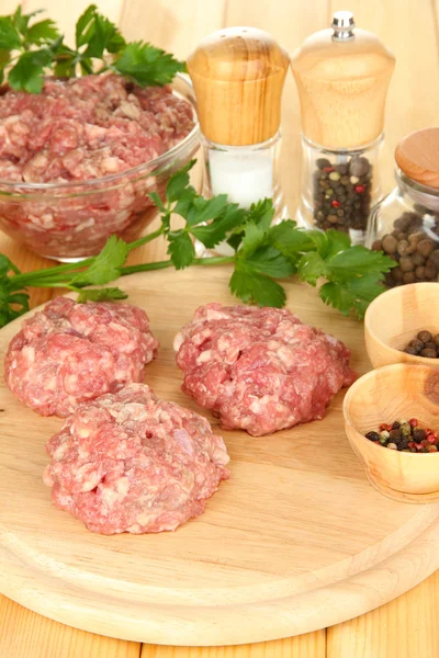 Raw meatballs with spices on wooden table — Stock Photo, Image