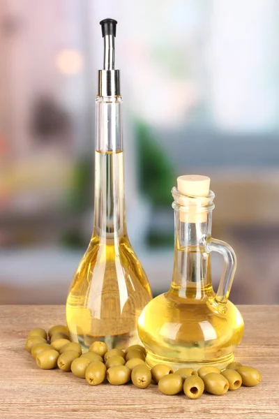 Different types of oil with olives on table in kitchen — Stock Photo, Image