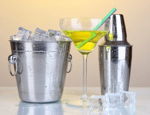 Eiskübel und Shaker aus Metall und Cocktail auf gelbem Hintergrund — Stockfoto