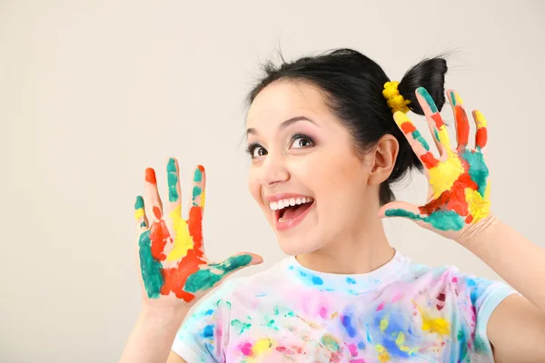Unga vackra målare med händer i färg, på grå bakgrund — Stockfoto
