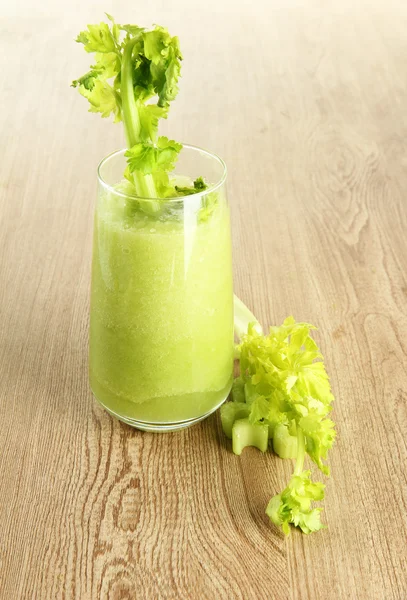 Glass of celery juice on wooden background