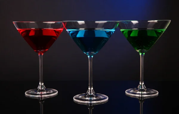 Cócteles alcohólicos en vasos de martini sobre fondo azul oscuro —  Fotos de Stock