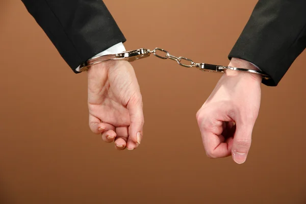 Man and woman hands and breaking handcuffs on color background — Stock Photo, Image