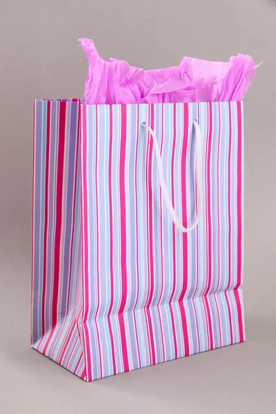 Shopping bag a righe su sfondo grigio — Foto Stock