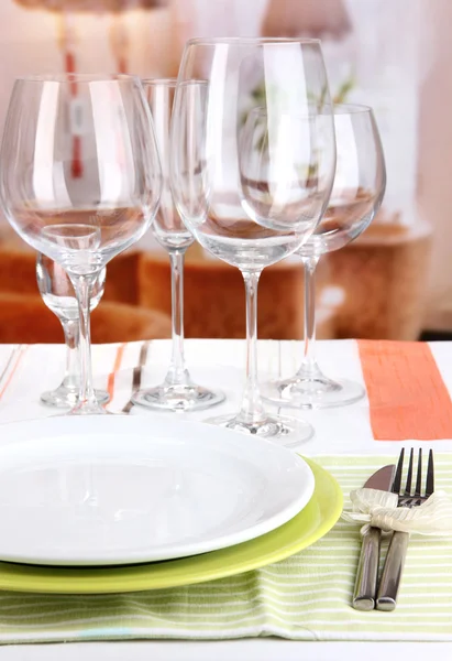 Ajuste de mesa con vasos para diferentes bebidas en la mesa sobre el fondo de la habitación —  Fotos de Stock