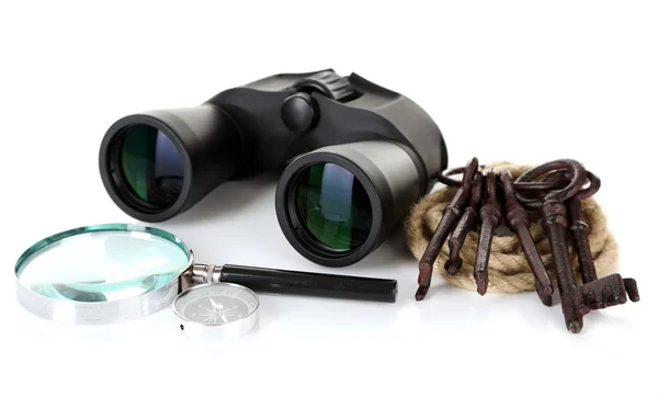 Black modern binoculars with magnifying glass, compass and old keys isolated on white — Stock Photo, Image